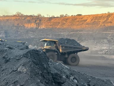 A loaded Komatsu haul truck pulling away from the loading point at first light.